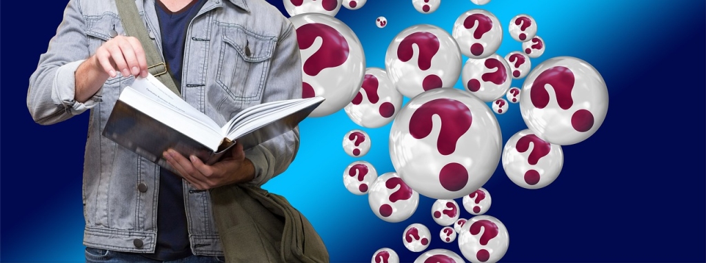 A person holding an open book (only the top part of their body is visible), with lots of white bubbles floating past them, each carrying a red question mark