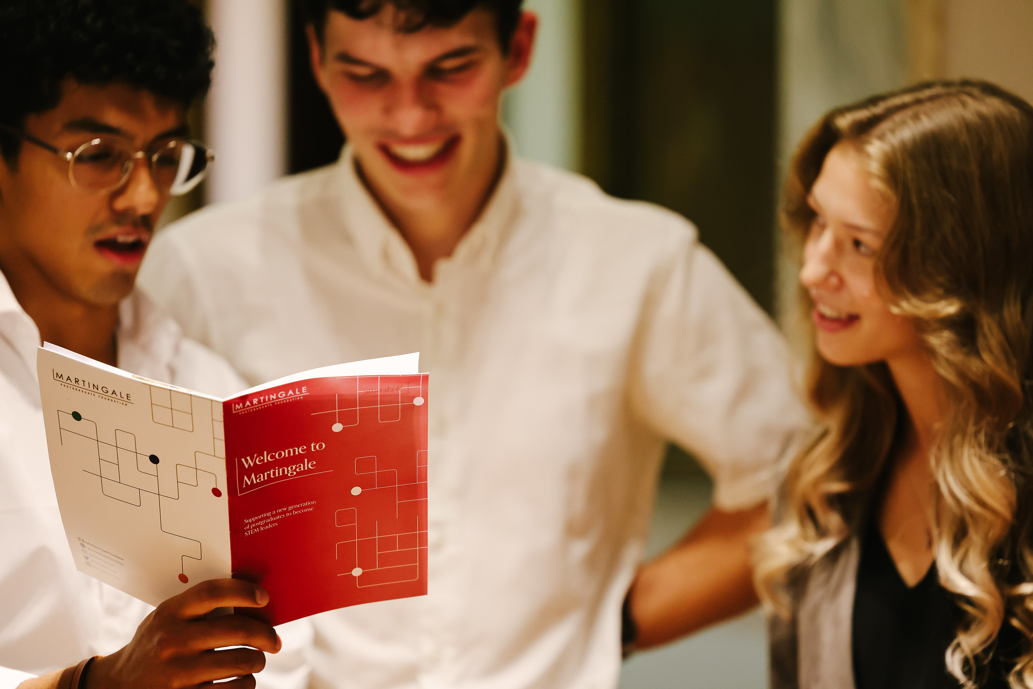 A photo of 3 students reading a booklet entitled 'Welcome to Martingale'.