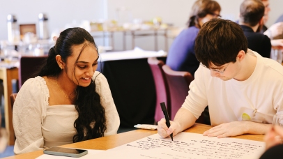 Two students sitting at a table working on a task.