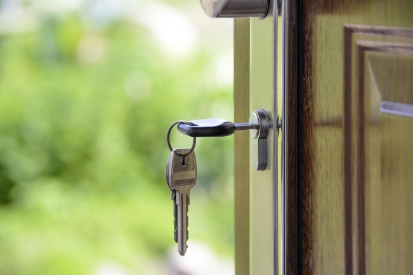 A door with keys in it opening onto an outside space