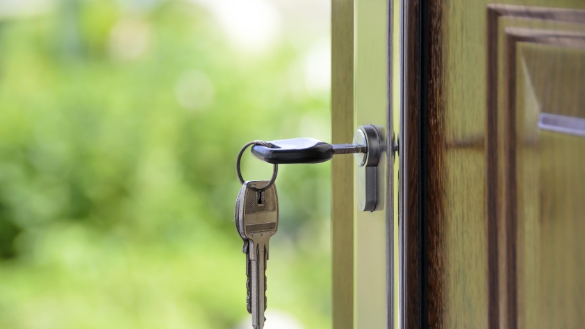 A door with keys in it opening onto an outside space